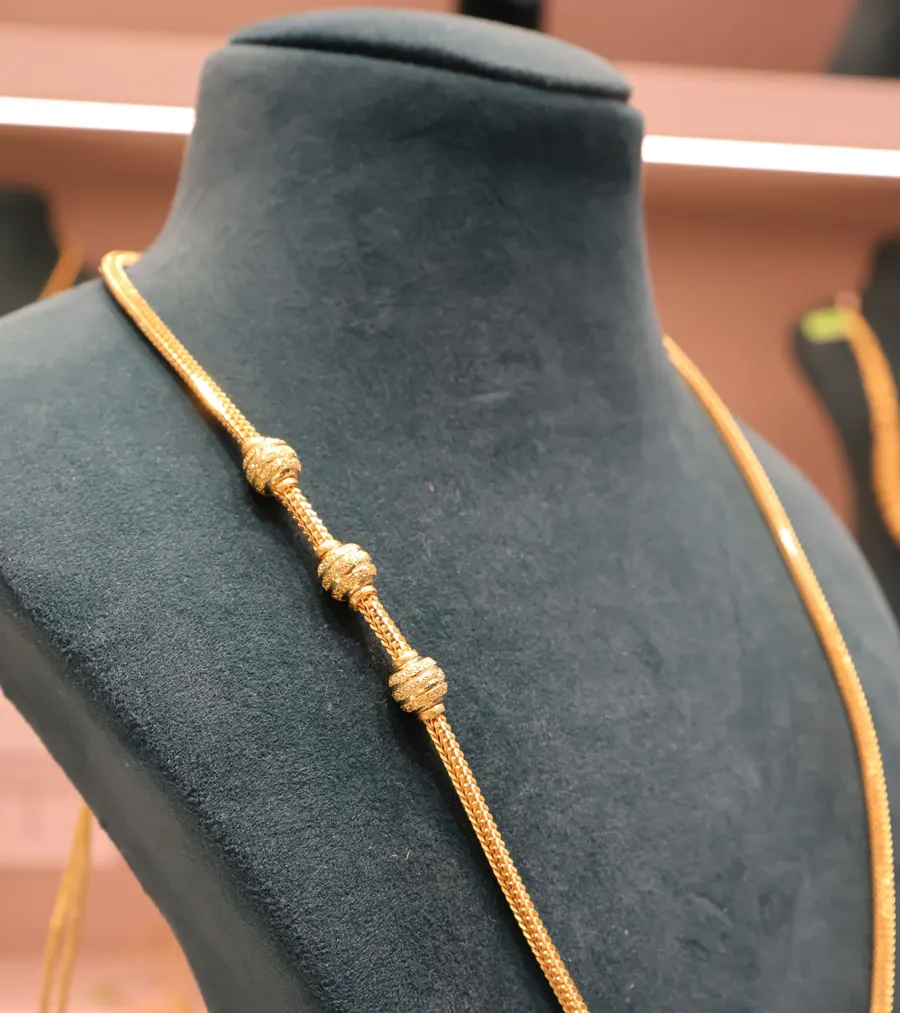 A long gold chain on a bust